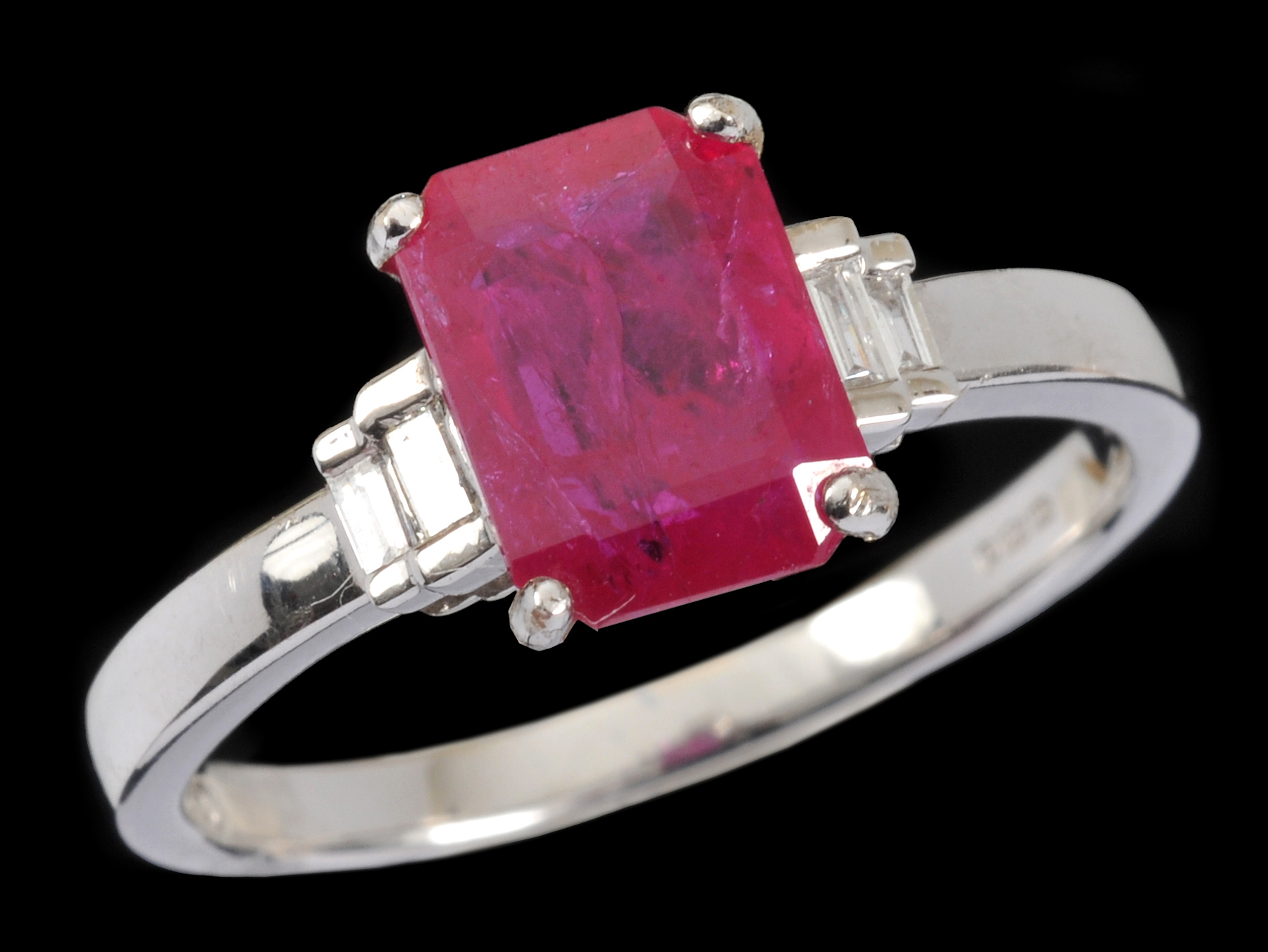 A Ruby and Diamond Ring corner claw-set step-cut ruby, 1.40cts, between two pairs of channel-set