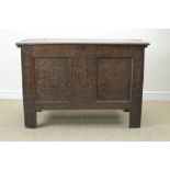 A 17th Century oak Coffer with plank lid having scratch carved edge, the two panel front carved