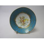 An 18th Century Sevres Saucer painted cherub amongst clouds with yellow ribbon and floral garland,