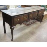 An 18th Century oak Dresser Base, the moulded top above three drawers and a shaped frieze, raised on