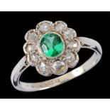 A Green Garnet and Diamond Cluster Ring millegrain-set oval-cut green garnet within a frame of