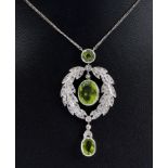 A Peridot and Diamond Necklace millegrain-set mixed-cut peridot suspended within laurel leaf frame