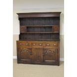 An 18th Century North Wales oak Dresser with canopy rack having small pair of arched panelled doors,