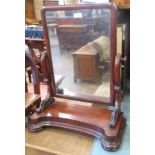A 19th Century mahogany Toilet Mirror, the rectangular plate on carved scrolled supports above a