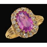 A Pink Sapphire and Diamond Cluster Ring claw-set oval-cut sapphire within a frame of old-cut