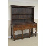 An antique oak Dresser and Rack with base fitted three drawers above silhouette supports and