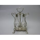 A George II silver two bottle Oil and Vinegar Cruet with central handle, rococo cartouche engraved
