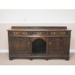 A George III oak Dresser Base fitted three drawers above two cupboards and a central 'dog kennel',