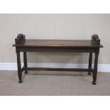 An early 20th Century oak Window Seat with solid seat on square section supports and H Stretcher,