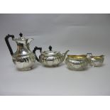 An Edward VII silver four piece Tea Service of gadrooned oval form with floral frieze and