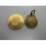 An 1856 USA gold Dollar with attached edge loop and a small gold Medal depicting Sir Winston