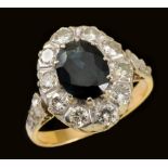 A Sapphire and Diamond Cluster Ring claw-set oval-cut sapphire within a frame of illusion-set