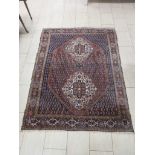 A bordered Persian Rug of medallion and corner design with all over boteh on a red and blue
