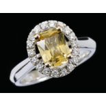 A Yellow Sapphire and Diamond Cluster Ring the radiant-cut sapphire, 1.29cts, within a halo frame of