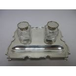 A George V silver oblong Inkstand fitted two square cut-glass Inkwells, on hoof feet, London 1910
