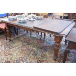 A Victorian mahogany Extending Dining Table with two spare leaves on turned and fluted tapering legs