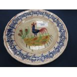 An early 20th Century Llanelly pottery cockerel Platewith a foliate rim, probably painted in a naive