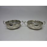 A pair of silver two handled lobed circular Strawberry Dishes with gadroon embossing, bears