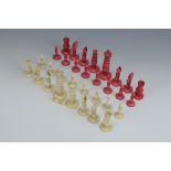 A turned ivory Chess Set with plain and red pieces having threaded bases, one pawn with base