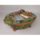 A Minton Majolica oval lidded Game Dish moulded hare and duck design to lid with branch handle and