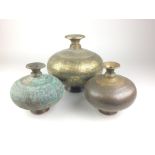 Three Indian engraved brass Lotas, Of compressed globular form, decorated with bands depicting