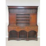 A 19th Century Montgomery stained pine Dresser and Rack, the upper section fitted two doors, the