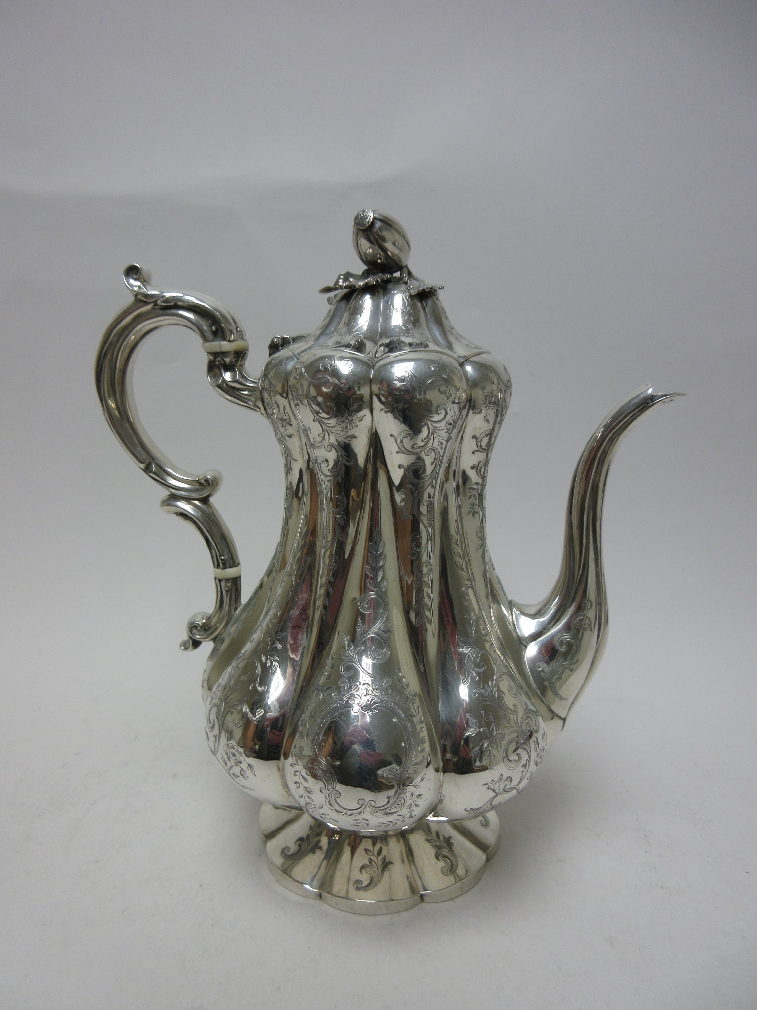 A Victorian silver Coffee Pot of pear shape with leafage scroll engraving, melon finial, London