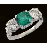 A Colombian Emerald and Diamond three stone Ring claw-set step-cut emerald 1.14cts, between two