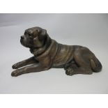 A Bretby pottery reclining Pug Dog with naturalistic detail and glass eyes, 16in, one leg A/