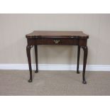 An 18th Century walnut Card Table having shaped fold-over top enclosing counter wells, freize drawer