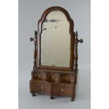 A Queen Anne style walnut Dressing Mirror with cushion moulded frame having arched top, the