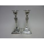 A pair of modern silver Candlesticks of classical form with ribbon, swag and pendant husk design