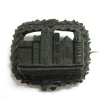 A 19th Century carved hardwood Brooch decorated with a possibly Scottish castle to the centre