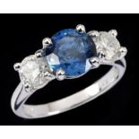 A Sapphire and Diamond three stone Ring claw-set round sapphire, 2.42cts, between two brilliant-