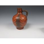 A Royal Lancastrian "Greek" style Jug with leaf panel designs in orange and brown, having loop