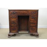 A George III mahogany Kneehole Desk with cross-banded top above one long and six small drawers,