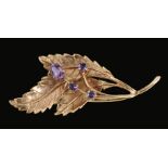 An Amethyst Leaf Spray Brooch claw-set one oval-cut and three round stones in 9ct gold