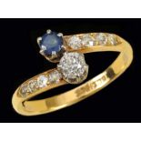 A Sapphire and Diamond Crossover Ring claw-set single round sapphire and brilliant-cut diamond