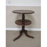 A George IV mahogany two tier circular Dumb Waiter on turned column with leafage carved tripod base,