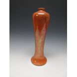 A tall Ruskin Vase of concave baluster form, having mottled orange egg shell iridescent glaze,