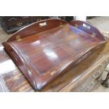 A George III mahogany Butler's Tray, the folding sides with pierced handles around a panelled