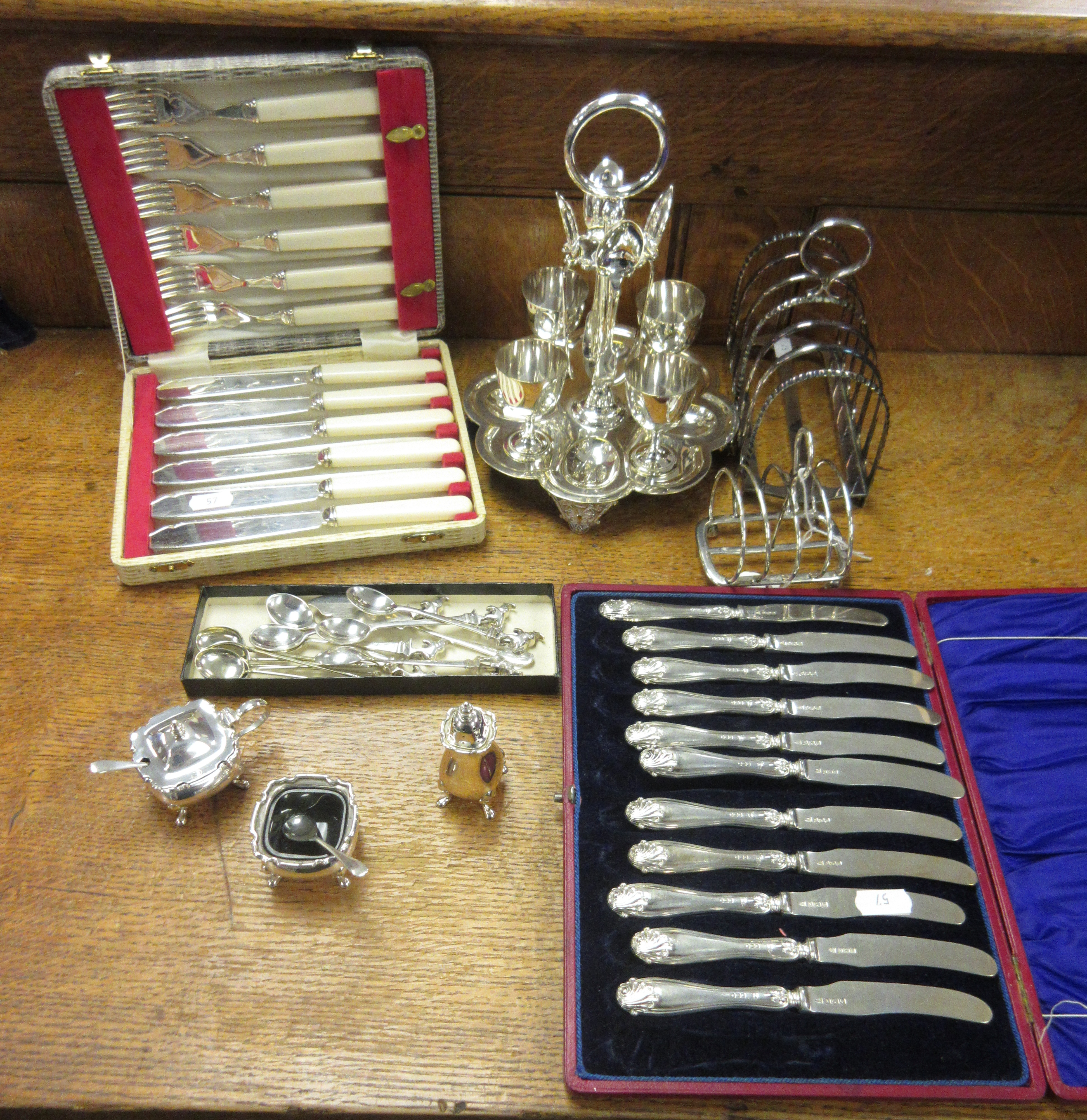 An Edward VII silver five bar Toastrack on ball feet, London 1904, a modern three piece Condiment