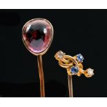 A Garnet Stick Pin set cabochon and a Sapphire and Diamond Stick Pin claw-set two round sapphires