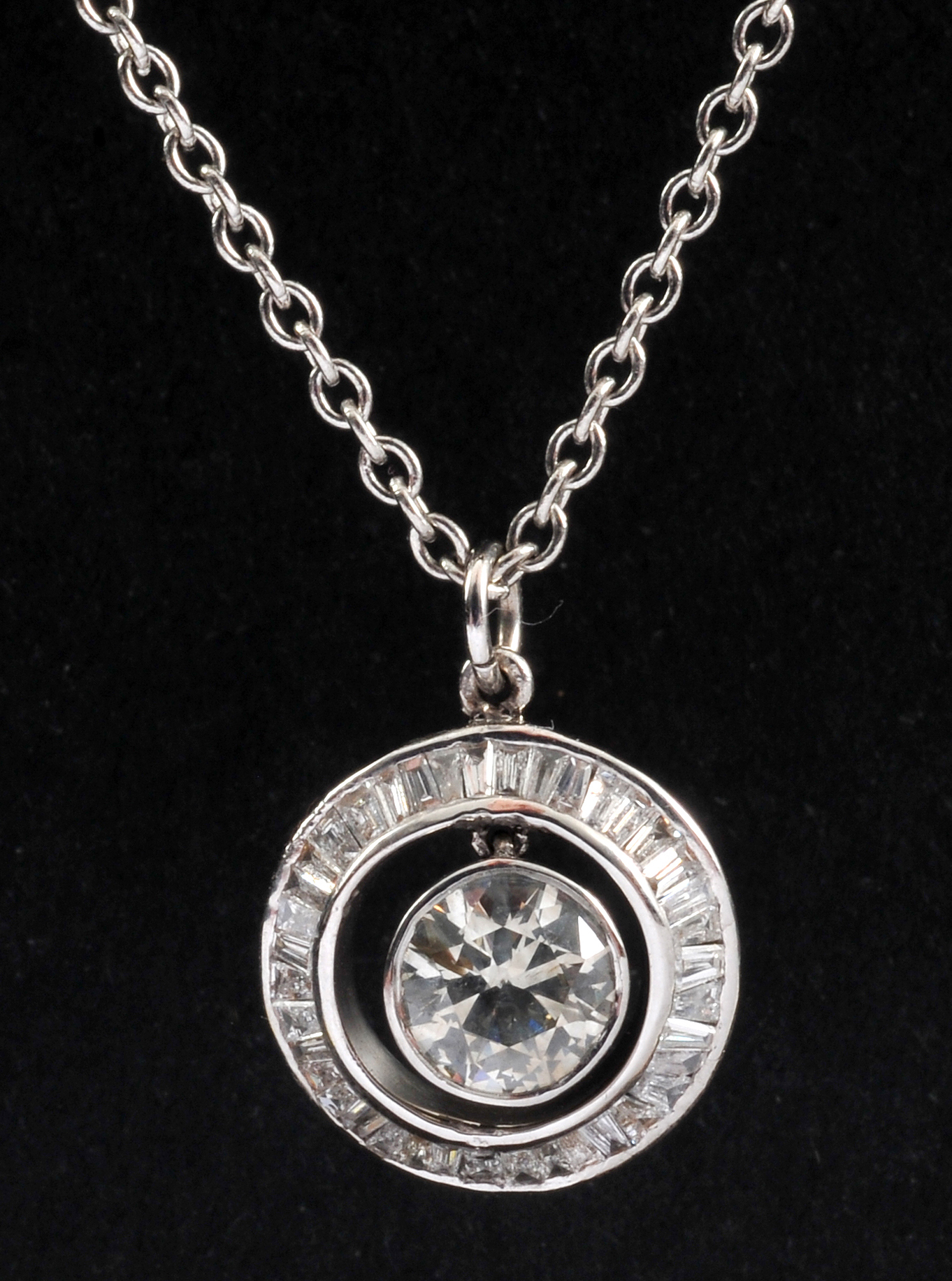 A Diamond Pendant rub-over set brilliant-cut stone, 0.68cts, suspended within frame of channel-set