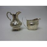 A George III silver oval Milk Jug with engraved friezes and reeded rim, London 1802 and a