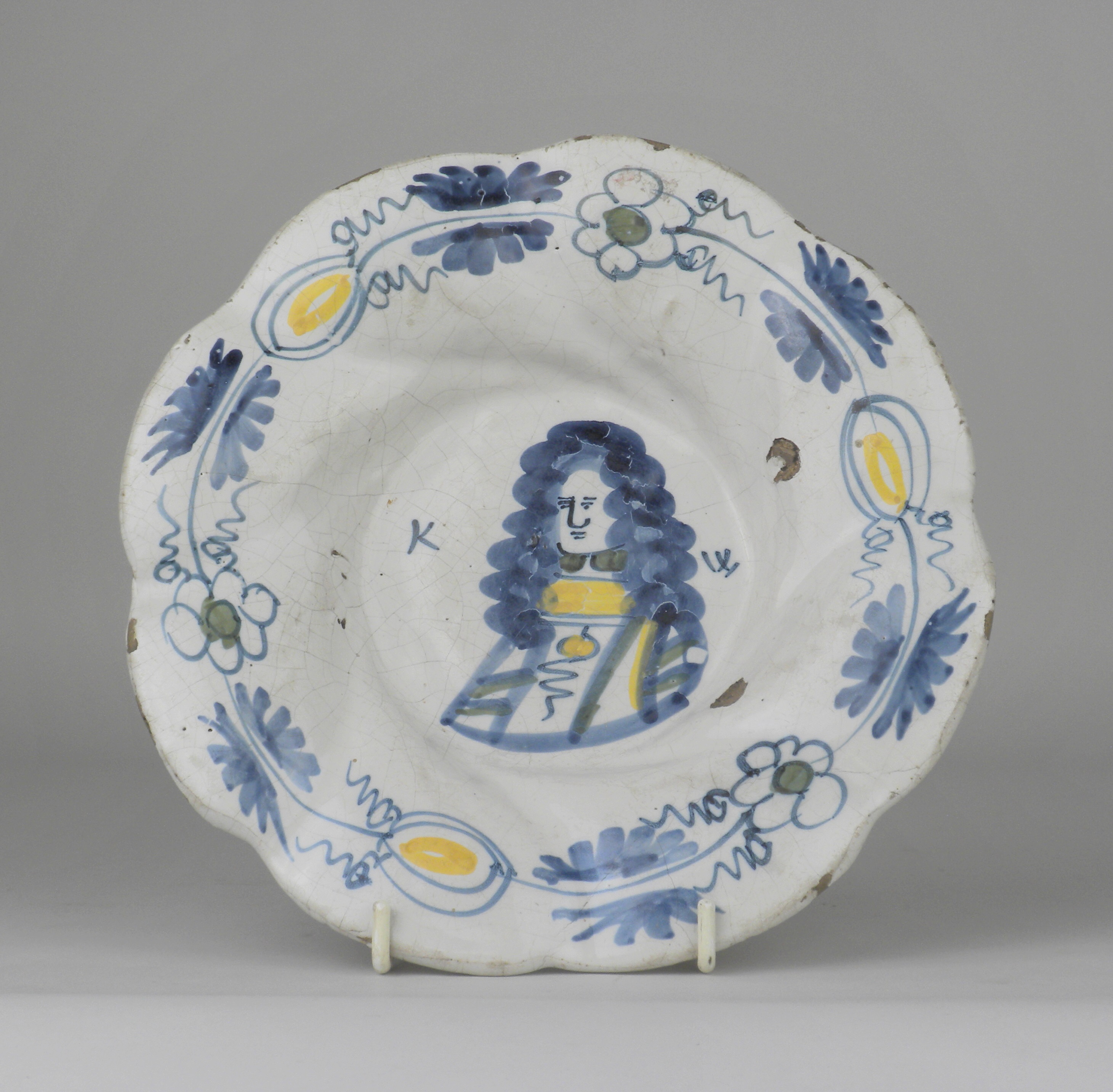 A late 17th Century Dutch Delft lobed Dish, painted to the centre with a naive portrait of William