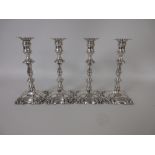 A set of four William IV silver Candlesticks with knopped stems engraved crests on shaped square