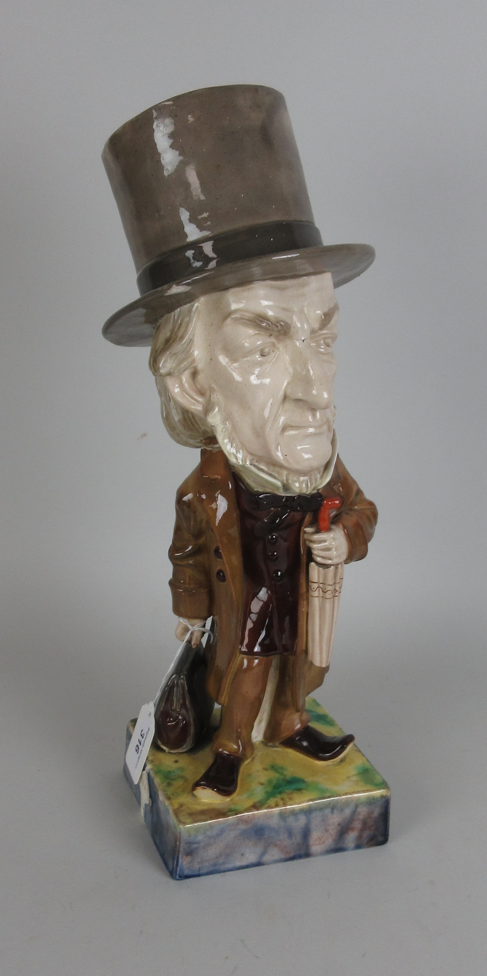 A Wayte and Ridge pottery caricature Figure of Gladstone, standing figure holding umbrella and