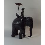 A Carved Ebonised Study of an Elephant with Rider and Attendant with Umbrella 40cm High