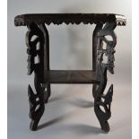 A Carved Indo Chinese Hardwood Two Tier Stand with Elephant Decoration and Pierced Supports.